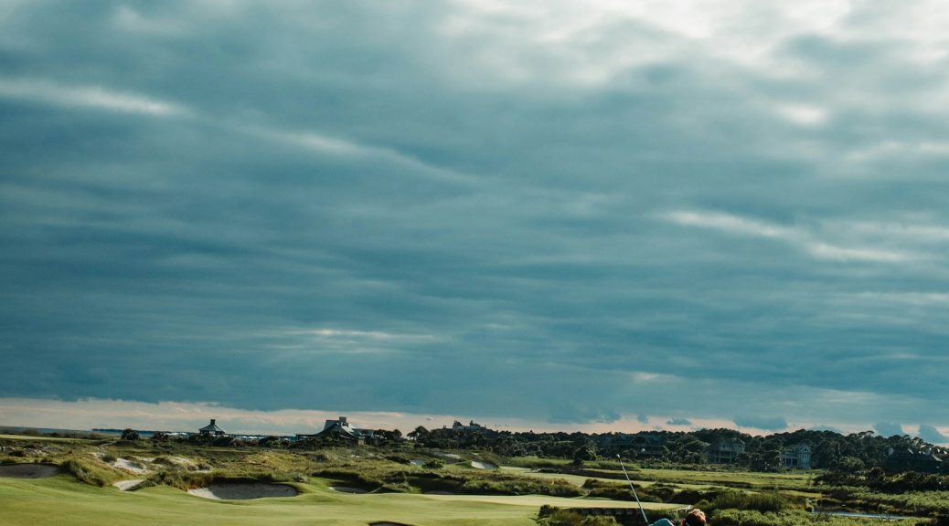 Golfer hitting approach shot on a links-style course